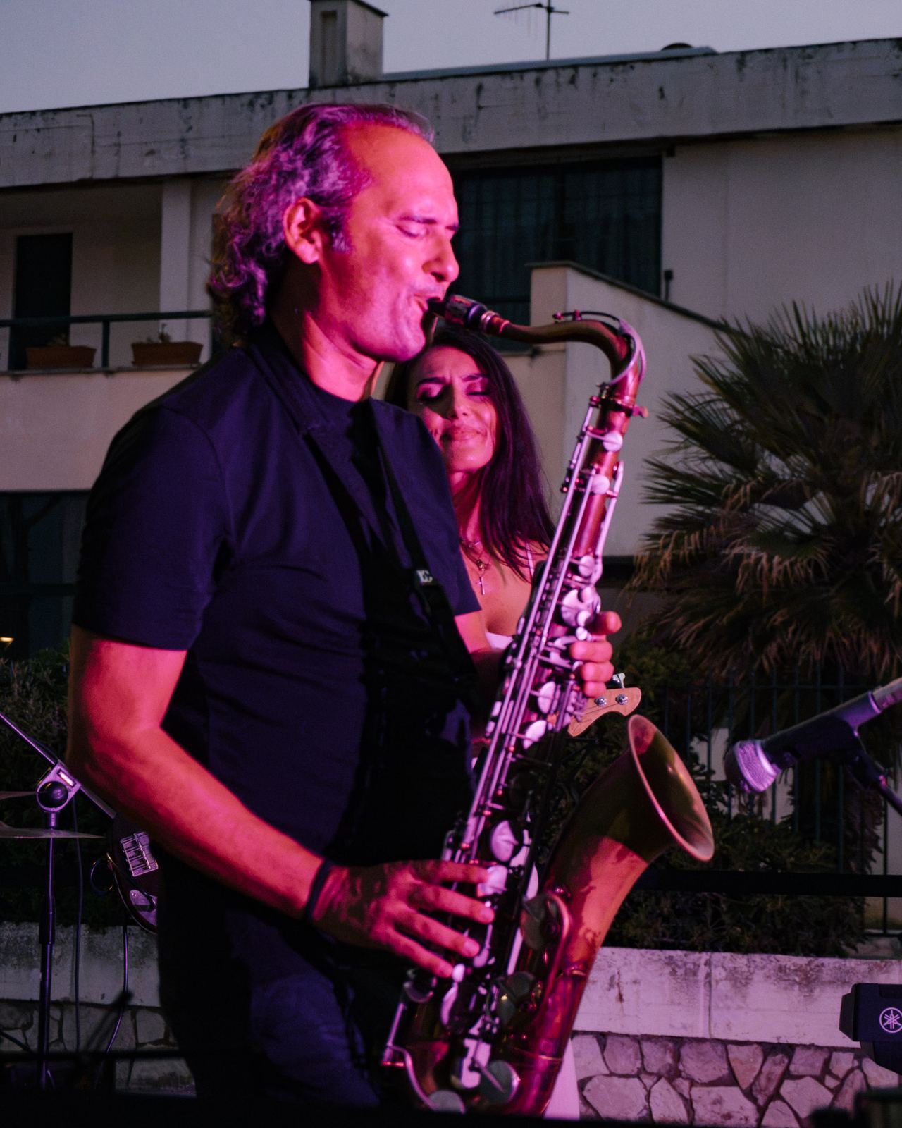 Sassofonista illuminato dalle luci del palco durante un concerto