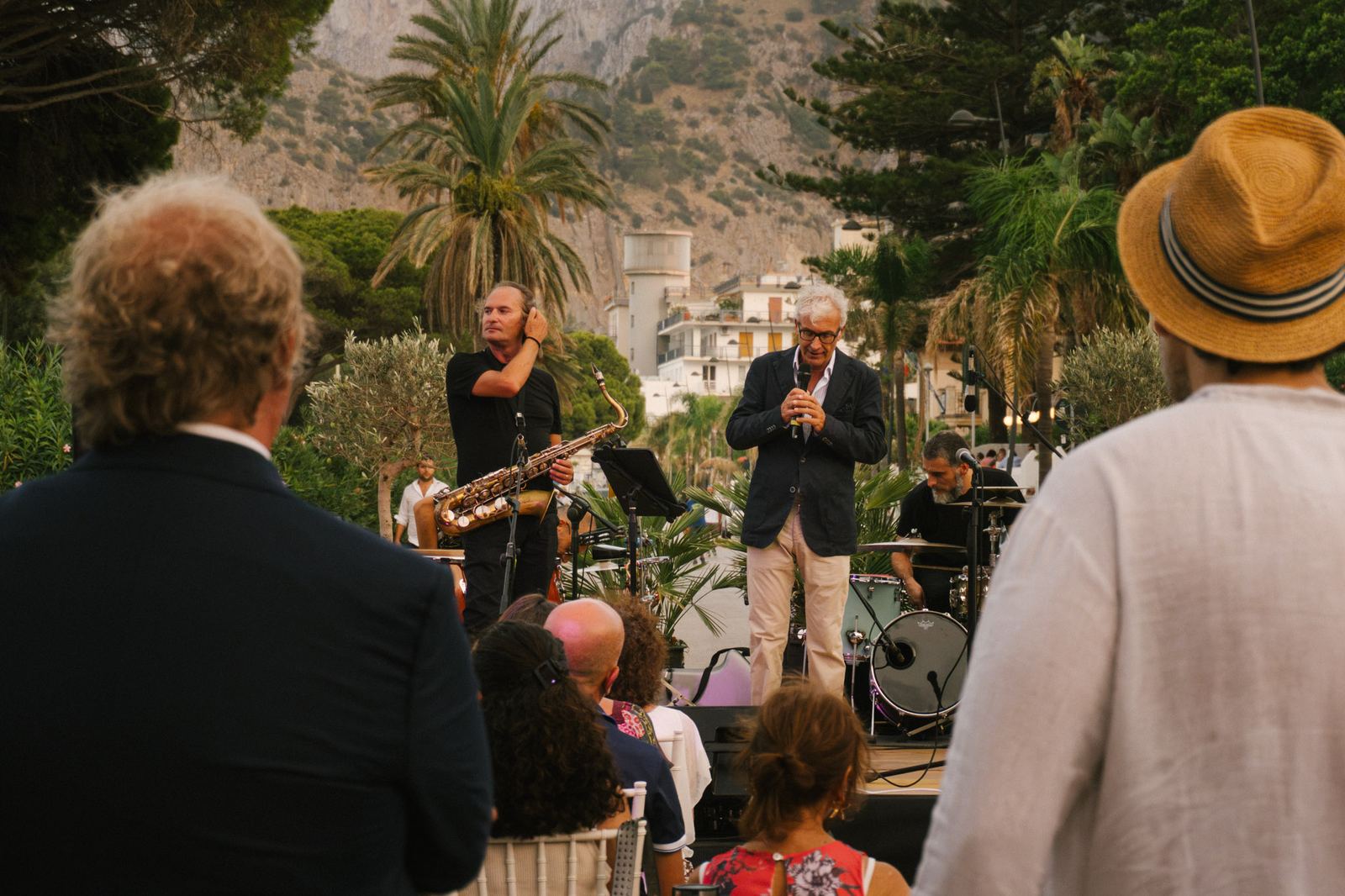 Pubblico e musicisti durante un concerto in piazza al tramonto