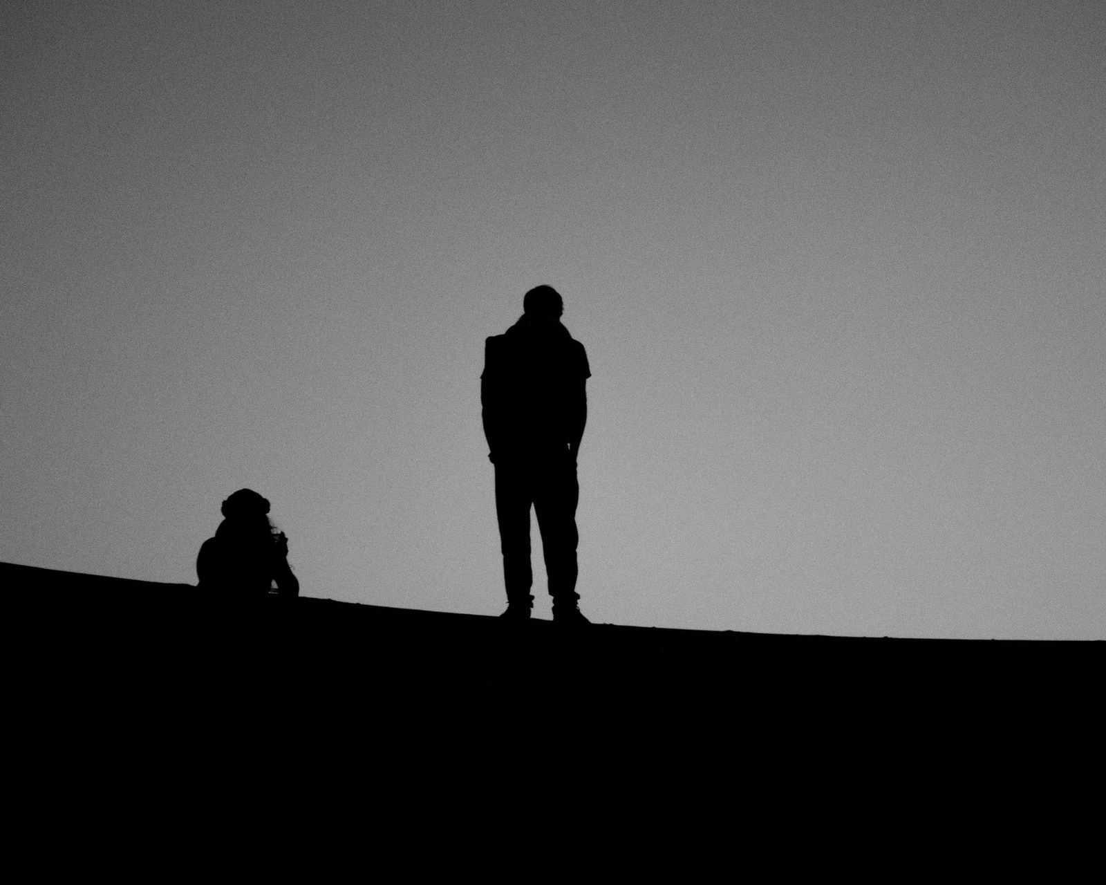 Due figure in controluce sul crinale di una duna