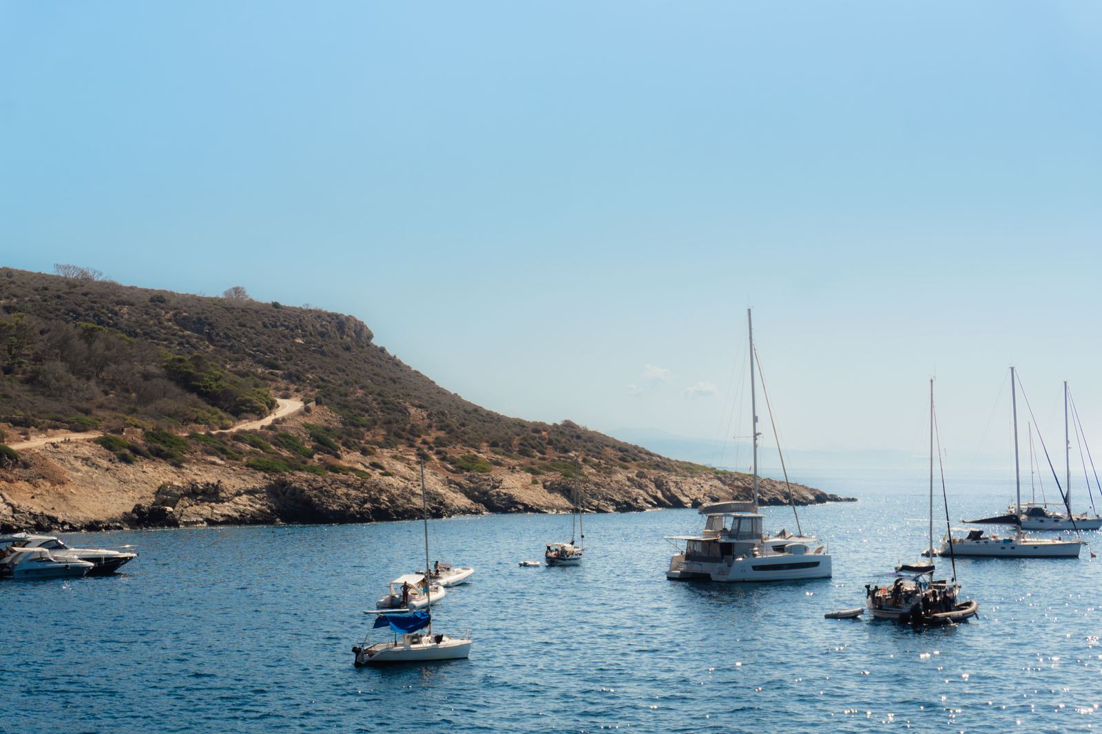 Barche a vela ormeggiate in una baia dalle acque trasparenti